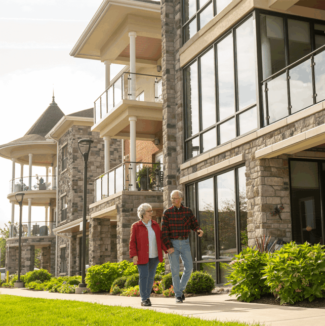 A couple tours a senior living campus as part of how to apply or senior living