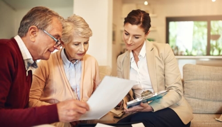 An older couple meeting with senior living advisor, sitting on a couch