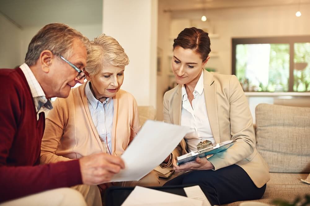 An older couple meeting with senior living advisor, sitting on a couch