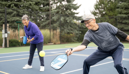 A man and a woman play pickleball, showcasing healthy living after 60