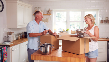An older couple packs up their kitchen into boxes as they downsize