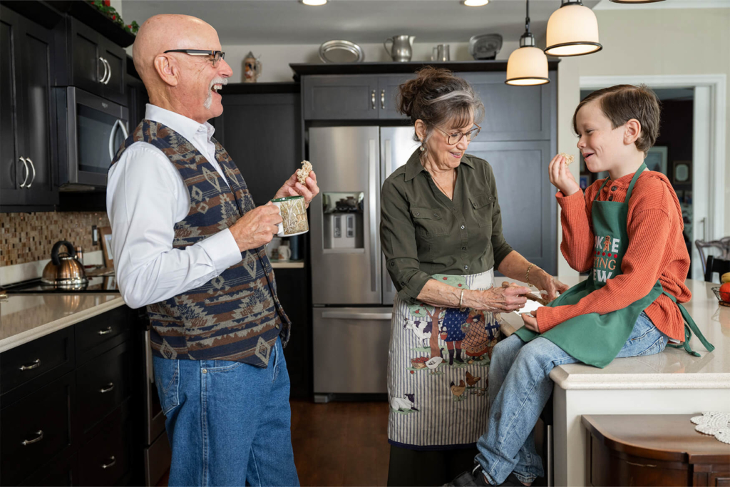 An older couple laughs with their grandson in the kitchen of their 1-bedroom senior apartment in Lancaster PA