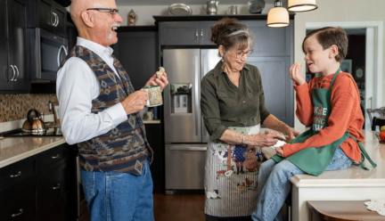 An older couple laughs with their grandson in the kitchen of their 1-bedroom senior apartment in Lancaster PA