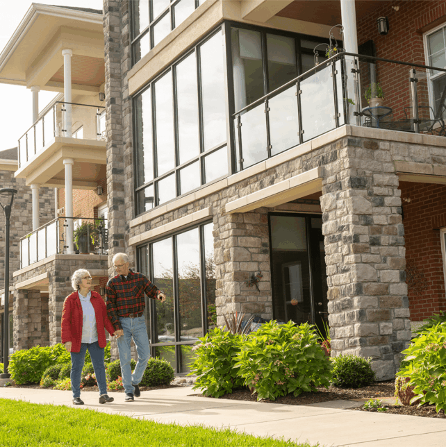 Older couple walking on a sidewalk during a senior living open house