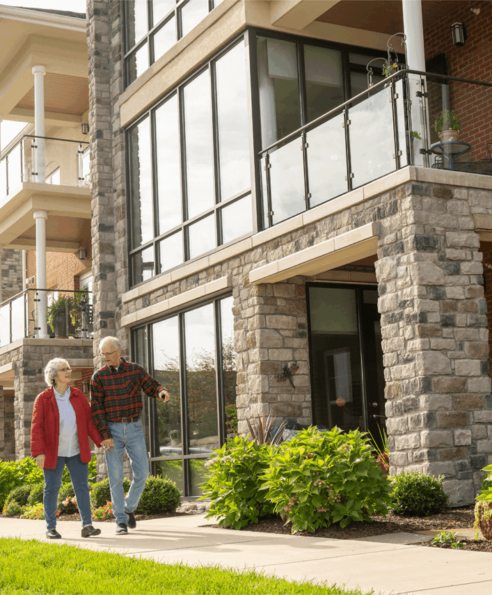 Older couple walking on a sidewalk during a senior living open house