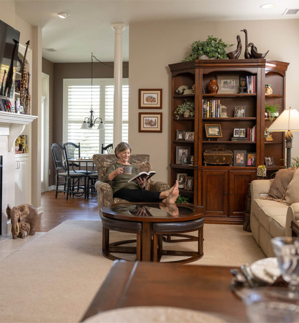 Woman lounging inside her senior living apartment