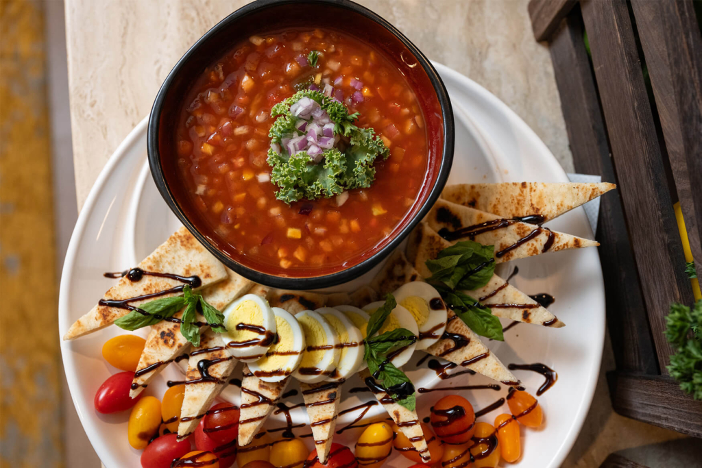 A plate of bread drizzled with balsamic glaze and a bowl of soup at a retirement community