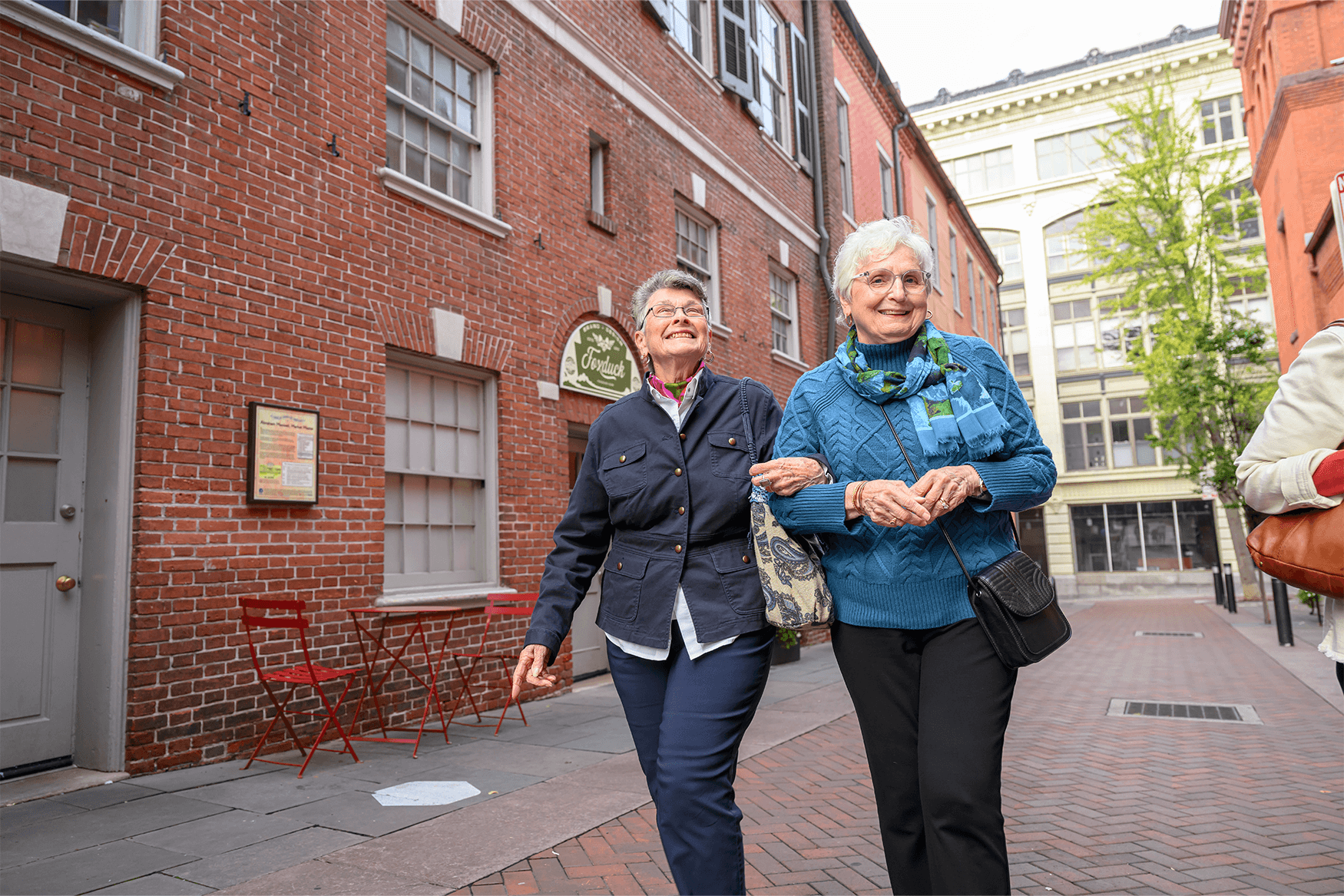 Residents of a senior living community near Lititz, PA hook arms and walk down the street