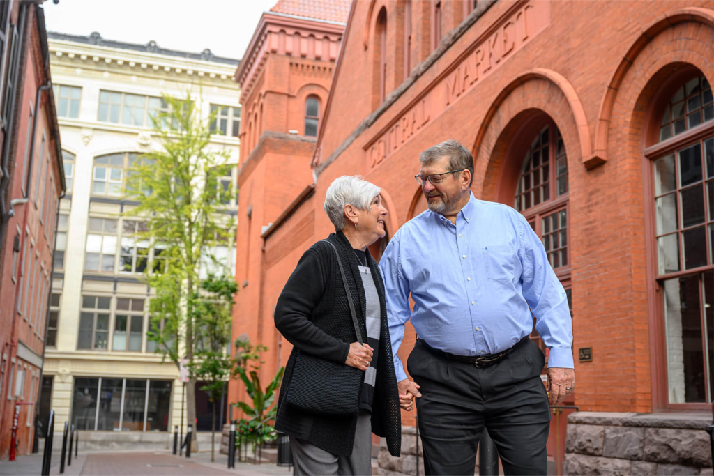 An elderly couple holds hands and enjoys social activities for seniors in downtown Lancaster