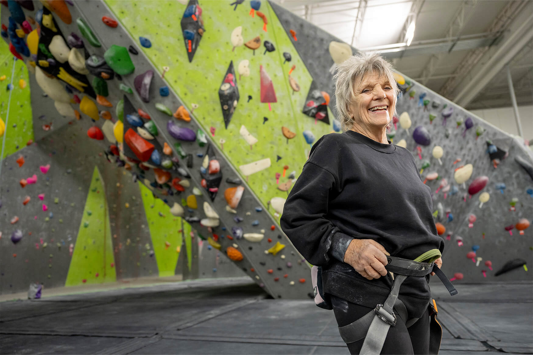 An older woman stays active at a rock climbing gym
