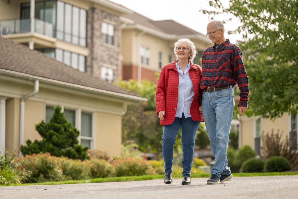 An older couple takes a senior living campus tour as they consider joining the waitlist