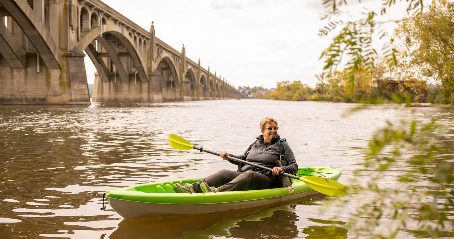 A resident of the Bloom Wellness Woodcrest Villa program kayaks in the fall