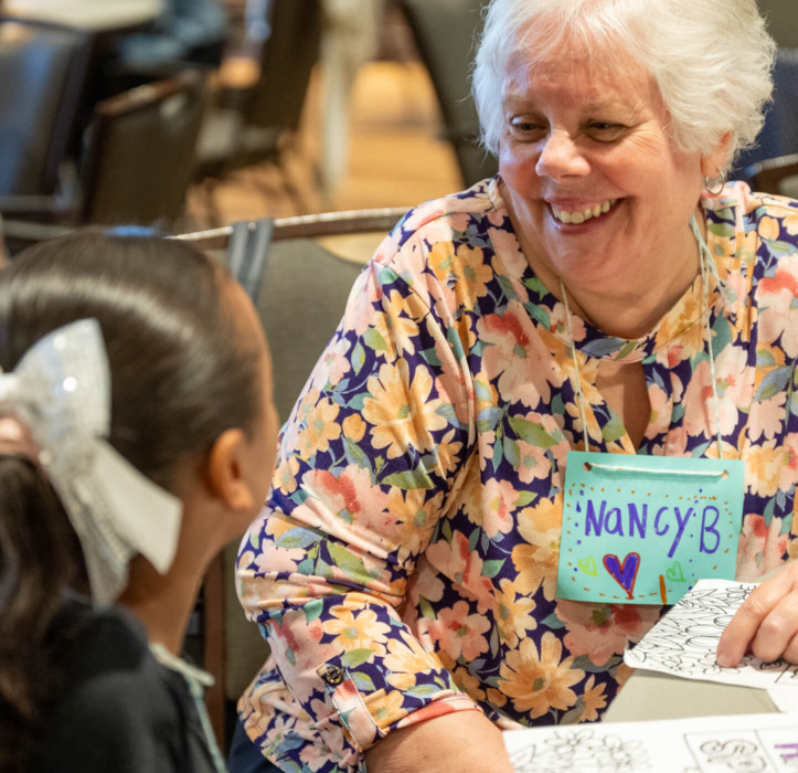 A female resident in the Bloom Wellness Woodcrest Villa program smiles at a little girl