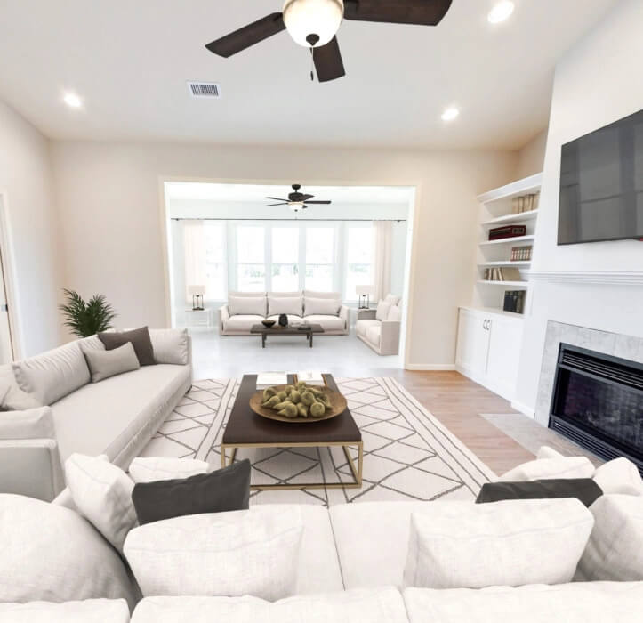 The Lancaster Villa with white and gray couches facing a coffee table with a TV mounted on the wall