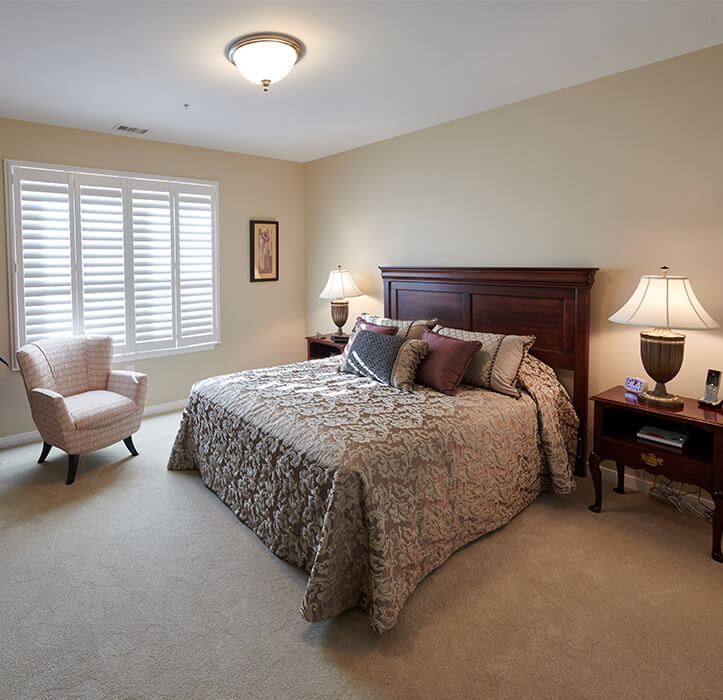 1-bedroom senior apartment with a big bed in the center of the room