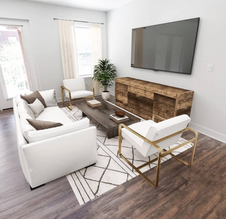 1-bedroom senior apartment with a den with a couch and chair facing a coffee table with a TV mounted on the wall