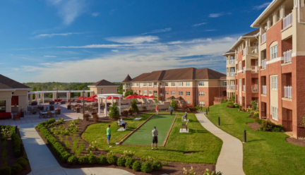 A few senior living residents play bocce ball on a sunny day on the Woodcrest Villa campus