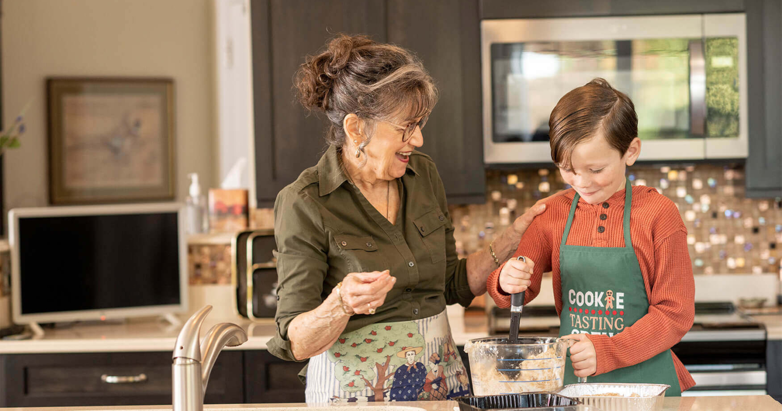 A resident of a retirement community in Lancaster County, PA, cooks in the kitchen with her grandson